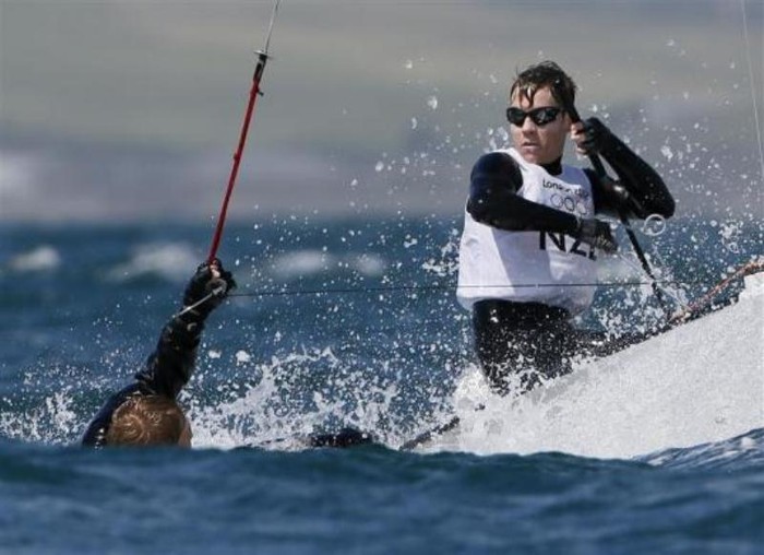 Jason Saunders (New Zealand) ngã xuống nước trong lúc cùng đồng đội Paul Snow-Hansen thi đấu ở môn đua thuyền buồm.